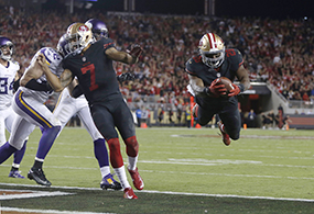 San Francisco 49ers' Carlos Hyde (28) dives into the end zone for a touchdown with San Francisco 49ers quarterback Colin Kaepernick (7) helping block against the Minnesota Vikings during the second quarter on Monday, Sept. 14, 2015, at Levi's Stadium in Santa Clara, Calif. (Nhat V. Meyer/Bay Area News Group/TNS)