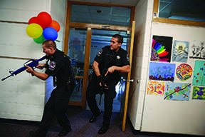 Two Cary police officers, including officer Anthony Tangorra, at right, carry blank weapons as they participate in an active shooter exercise with police, emergency workers, teachers and administrators Saturday, Sept. 12, 2015 at Oak Knoll School in Cary, Ill. (Anthony Souffle/Chicago Tribune/TNS)