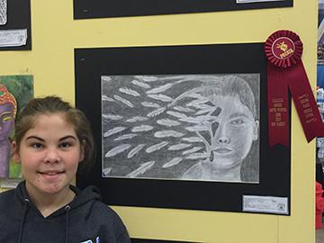 Sixth grader, Emma Kaminski displays her art piece.