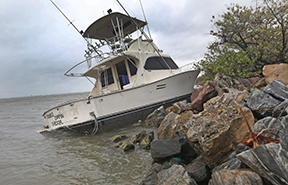 A cabin cruiser that probably had broken loose from its moorings sits among the rocks Thursday, October 7, 2016  along the Banana River.  Hurricane Matthew a Category 4 storm brushed the Florida east coast. (Red Huber/Orlando Sentinel/TNS)