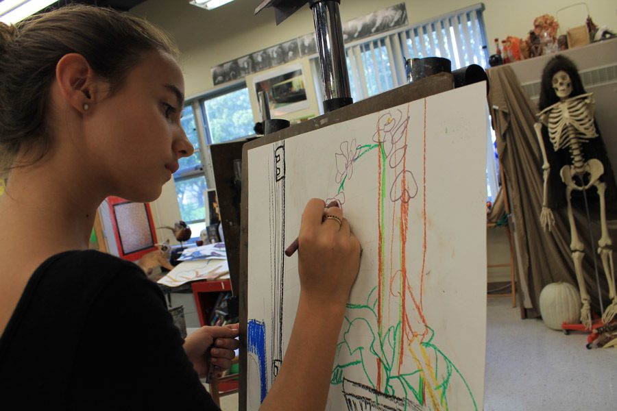 With a steady hand, Ali Spector, seventh grade visual major, works on her oil pastel still life. “I choose to draw the plant because I really like things that look like they are painted. I found it aesthetically pleasing,” Spector said.  