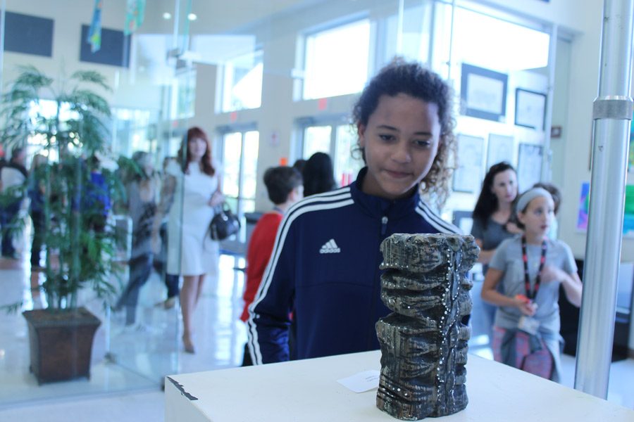 Julia Guilfu, seventh grade visual arts major, admires a tiki sculpture, one of the pieces included in the Art Explosion Gallery. The gallery showcase occurred on March 9. “The Art Explosion was important for the visual arts department as it’s not really an art we can perform so it was a way to show off our talents,” Guilfu said. “We also get to see what other artists have been doing.”