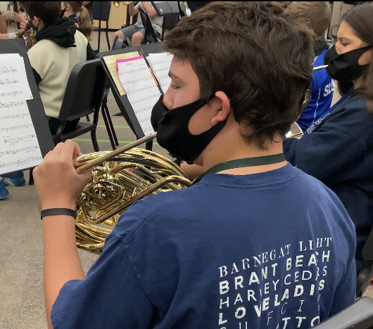 Practicing for an upcoming concert, Christian Degnan plays using a band mask.“It was annoying how we could not have as many people at our past concerts due to Covid, but I’m glad that now we are back to full capacity,” Christian Degnan, eighth grade band major said. 
