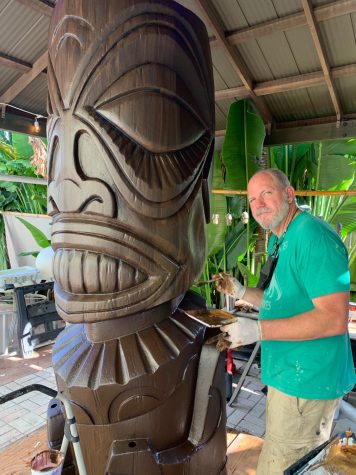 In his backyard, Glen Barefoot finalizes the tiki by painting on a wood appearance. This sculpture was designed for a hotel in Sarasota. Barefoot said, “I find the environment a little more positive than I would find in a regular gallery environment.” 