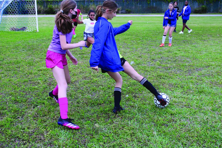 Defending her goal, seventh grade midfielder Genevieve Cox pressures the player on the other team. “I think the season will be good. We do scrimmages in practices, and we will practice things we need to improve on to be prepared for games,” Cox said. 