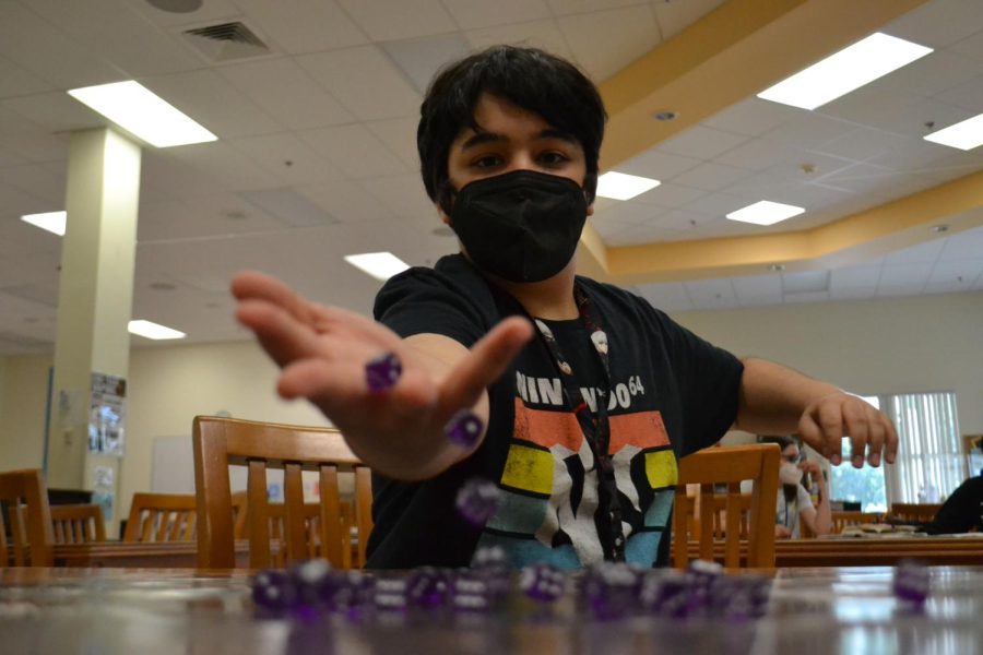 Attempting to roll a pair of sixes, Chase Bauer, sixth grade theater major, plays “HeroClix” in the media center.  “It’s [Geek Games] about students teaching and playing with other students,” Zane Hurley said. 
