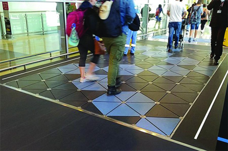 Passengers+and+staff+walk+over+a+set+of+%E2%80%9CPavegen%E2%80%9D+tiles+at+Abu+Dhabi+International+Airport+%28AUH%29.+The+tiles+function+by+converting+kinetic+energy+from+human+footsteps+into+electricity.