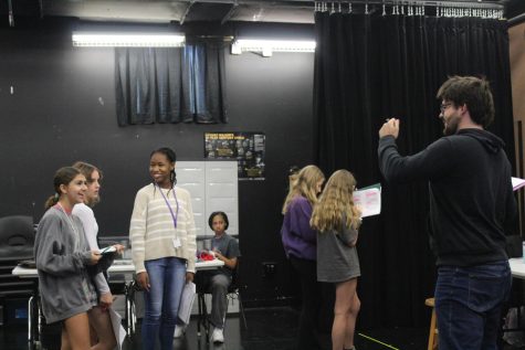 Eric Fredrickson preps his students, Sofia Carbone, Meya Cooper and Hannah Ledger for their upcoming performance. Using hands-on techniques that keep the students engaged and involved.
“I am also really putting into practice the things they might have learned in the previous class with objectives and tactics,” Eric Fredrickson, Theater teacher said. Photo by Shrenik Keshava
