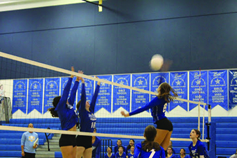 Hitting the ball, Isabella Rigaud, eighth grade middle front, wins the point. “Even at school, I work on the mistakes I make and go home and work on them. It improves my playing,” Riguad said. Photo by Gabby Cohen