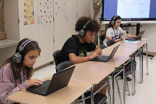 Katherine Kossove, sixth-grade visual major, Devin Jackson, eighth-grade theater major, and Izzy Ford, sixth-grade dance major finish up their homework in Ms. DeSilvas class. “Music would help me enjoy studying and doing work online.”Ford said “Listening to music helps me focus and I believe music will encourage learning in general”