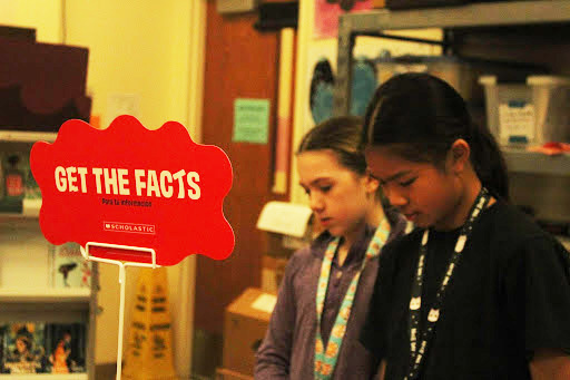 Chloe Conway, sixth-grade dance major and Riley Lam, sixth-grade dance major browsing books at the book fair. 