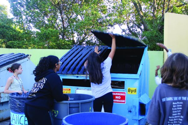 Mika Gonzales (8) opening the recycling dumpster for members to put their recycling in. “I love this club because I can help Mother Nature and help her stay clean,” Gonzales said. 