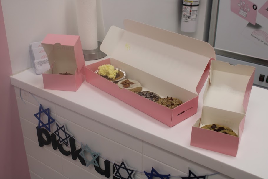 The cookies sit in the store waiting to be picked up. They are sets of four cookies and two sets of one cookie, in boxes on the counter for customers.