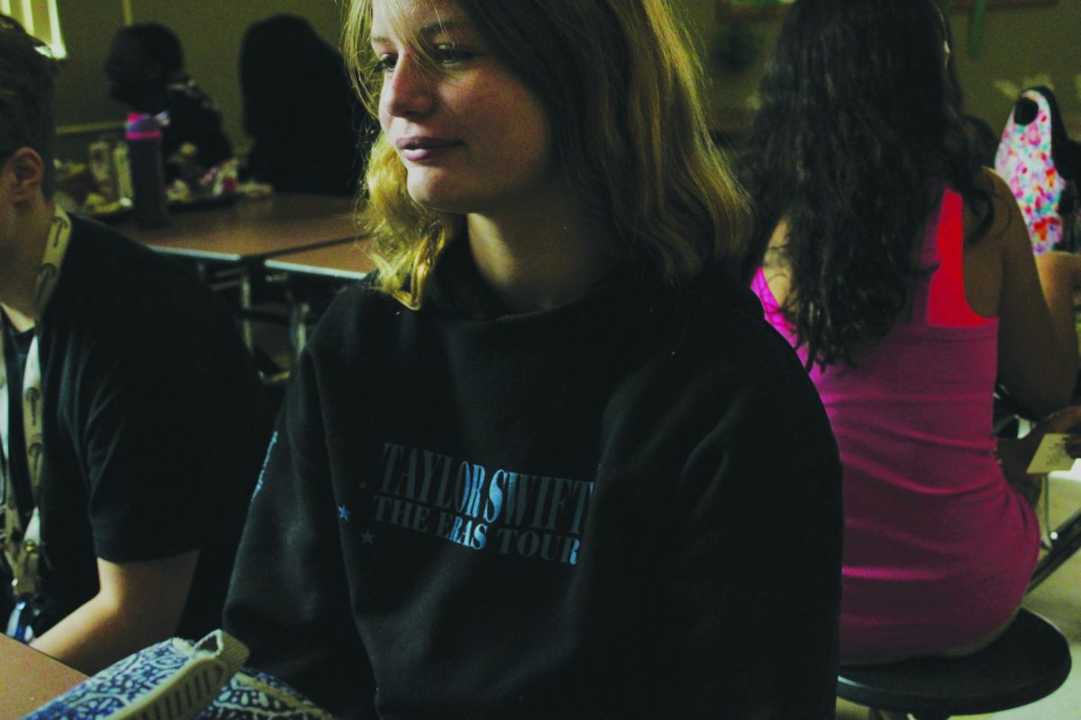 Pearl Phipps, eighth-grade visual major, wears a black and blue Taylor Swift hoodie. This hoodie, along with other merchandise, can be bought at her concert venues or the official Taylor Swift website.